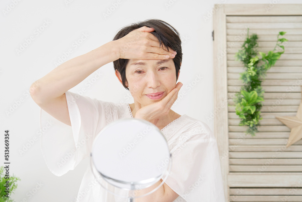 自宅でフェイシャルケアをする中年女性