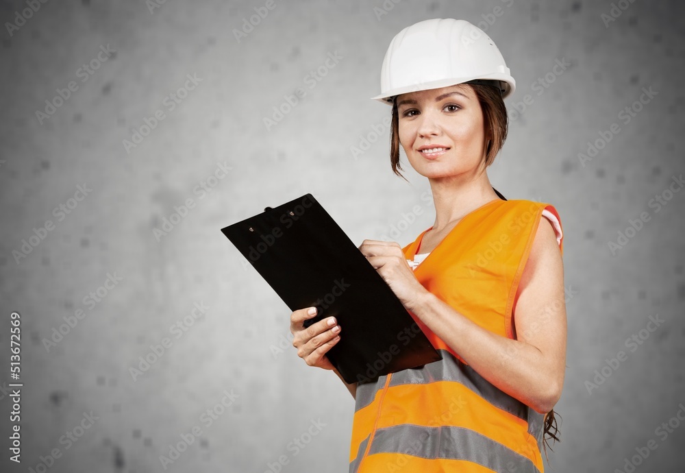 Studio portrait of lady or female engineer wearing a safety helmet and a reflective jacket Studio portrait of lady or female engineer wearing a safety helmet and a reflective jacket