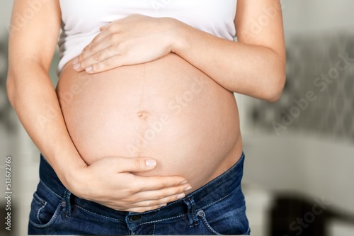 A young pregnant woman touching her belly and caring about her health © BillionPhotos.com