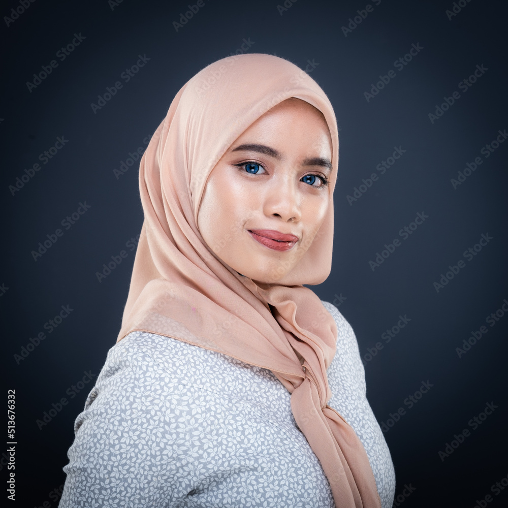 Close up portrait of a beautiful female model wearing traditional dress and hijab, a lifestyle apparel for Muslim women isolated on grey background. Idul Fitri and hijab fashion concept. Close up portrait of a beautiful female model wearing traditional dress and hijab, a lifestyle apparel for Muslim women isolated on grey background. Idul Fitri and hijab fashion concept.