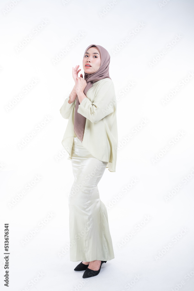 Beautiful female model in poses wearing traditional apparel and hijab, an urban lifestyle look for Muslim women isolated on white background. Beauty and hijab fashion concept. Full length Beautiful female model in poses wearing traditional apparel and hijab, an urban lifestyle look for Muslim women isolated on white background. Beauty and hijab fashion concept. Full length