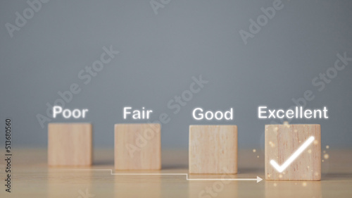 Evaluation and satisfaction concept. On wood blocks, a correct mark shows an excellent job and best service for customer. Copy space on grey background.