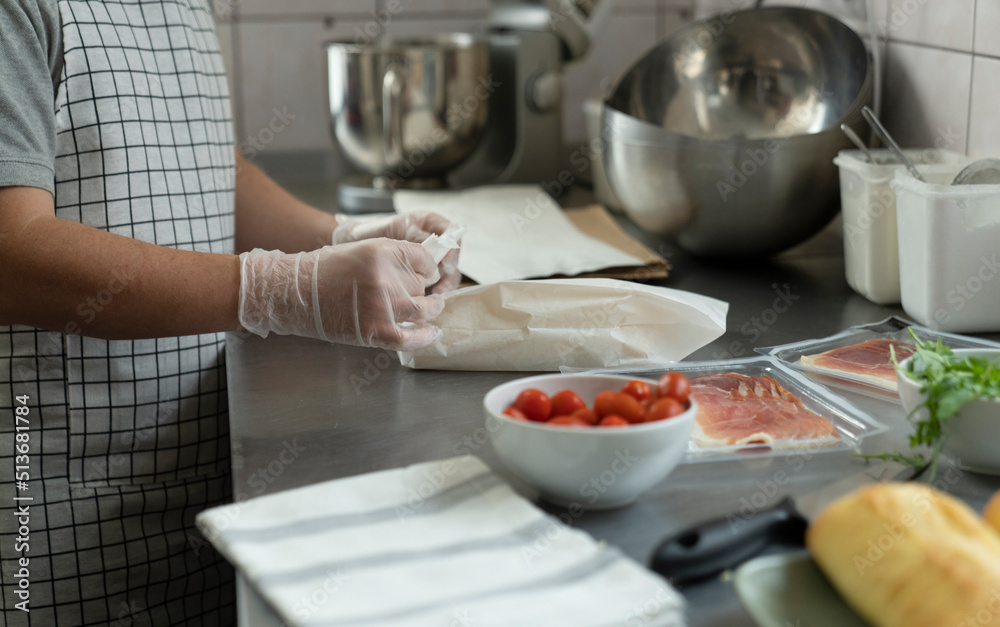 Unrecognizable man preparing a sandwich in commercial kitchen Unrecognizable man preparing a sandwich in commercial kitchen
