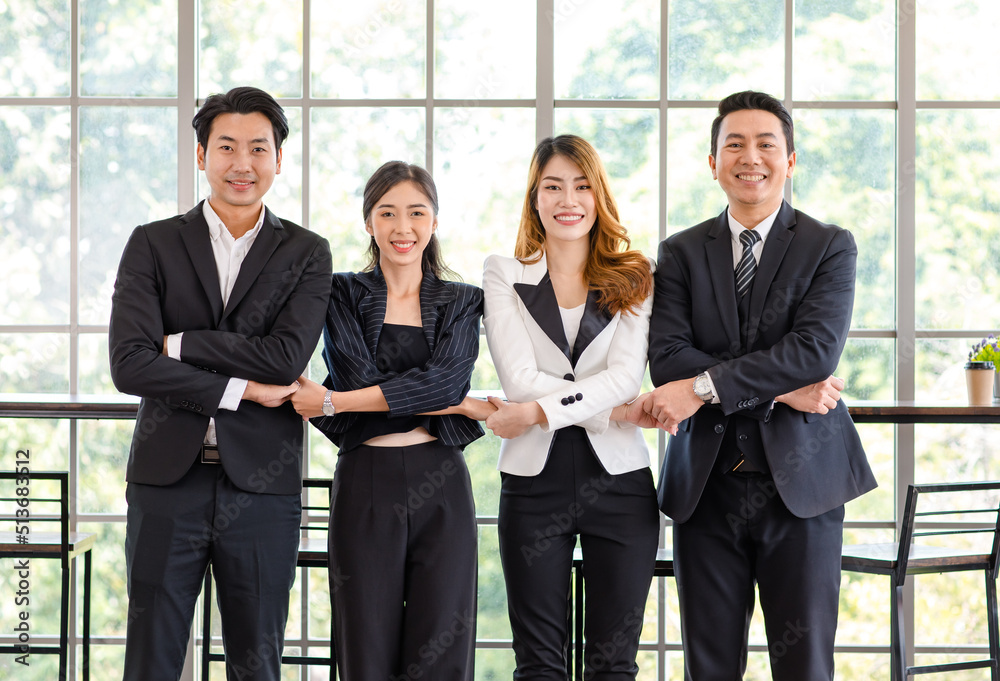 Portrait shot group of Asian happy cheerful millennial professional successful male businessman and female businesswoman in formal suit standing smiling cross hands holding together showing teamwork Portrait shot group of Asian happy cheerful millennial professional successful male businessman and female businesswoman in formal suit standing smiling cross hands holding together showing teamwork