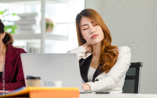 Asian young doubtful thoughtful confused female businesswoman sitting thinking pondering at workstation holding hand scratching head while using laptop notebook computer working in company office