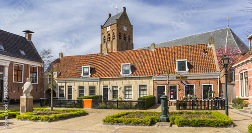 Central square with houses and church tower in Ferwert, Netherlands photo