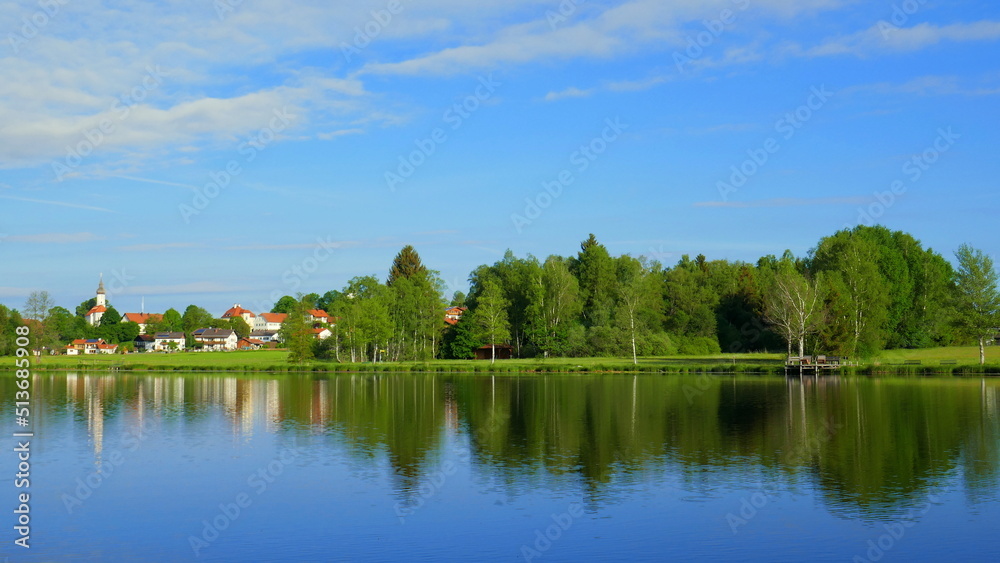 Blick über stillen Bad Soier See auf Bayersoien mit Spiegelung von Dorf und Wald unter blauem Himmel Blick über stillen Bad Soier See auf Bayersoien mit Spiegelung von Dorf und Wald unter blauem Himmel