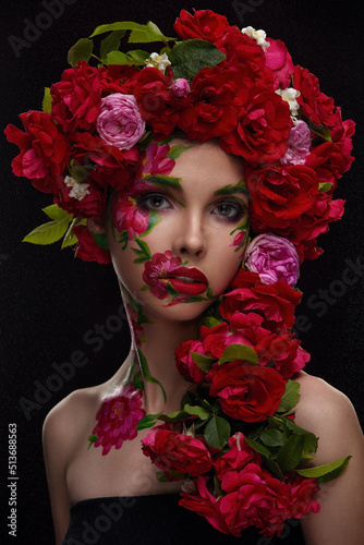 Portrait of a beautiful girl with exquisite makeup and a wreath of red tea roses
