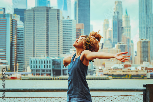 Photography Portrait beautiful young adult woman afro hairstyle with open arms and Manhattan