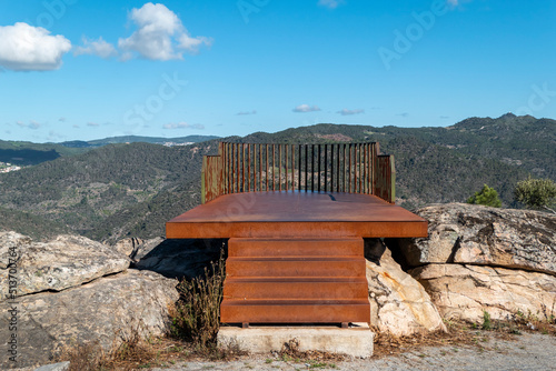 Entre montanhas e algumas rochas o miradouro Olhos do Tua Em Castanheiro do Norte, Portugal. Estrutura metálica com tons avermelhados de ferrugem em cima de alguns rochedos photo