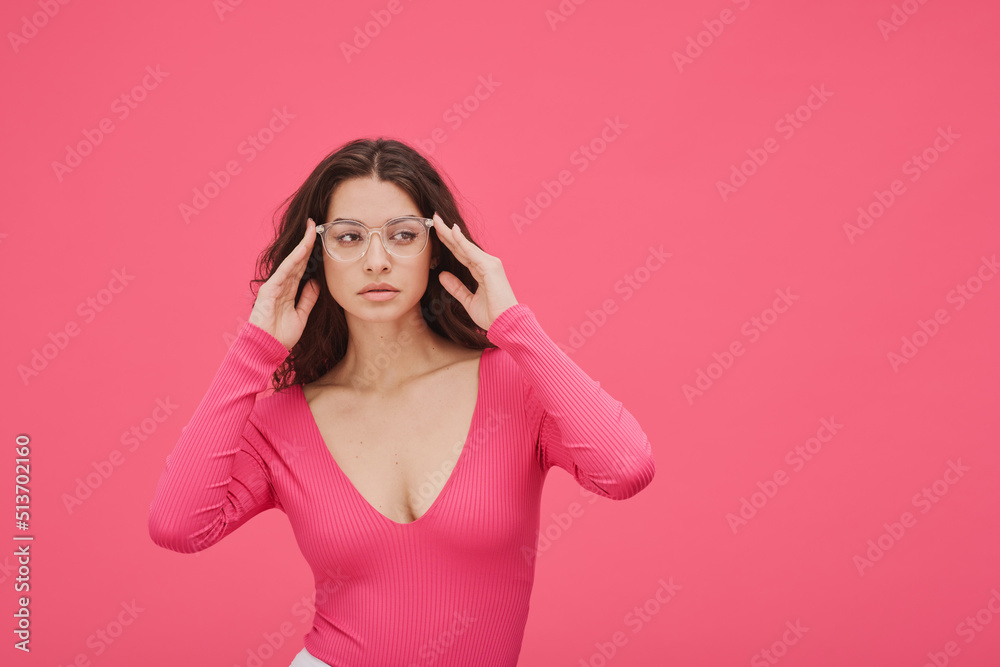 Portrait of young pretty woman in pink posing in stylish eyeglasses on pink background Portrait of young pretty woman in pink posing in stylish eyeglasses on pink background