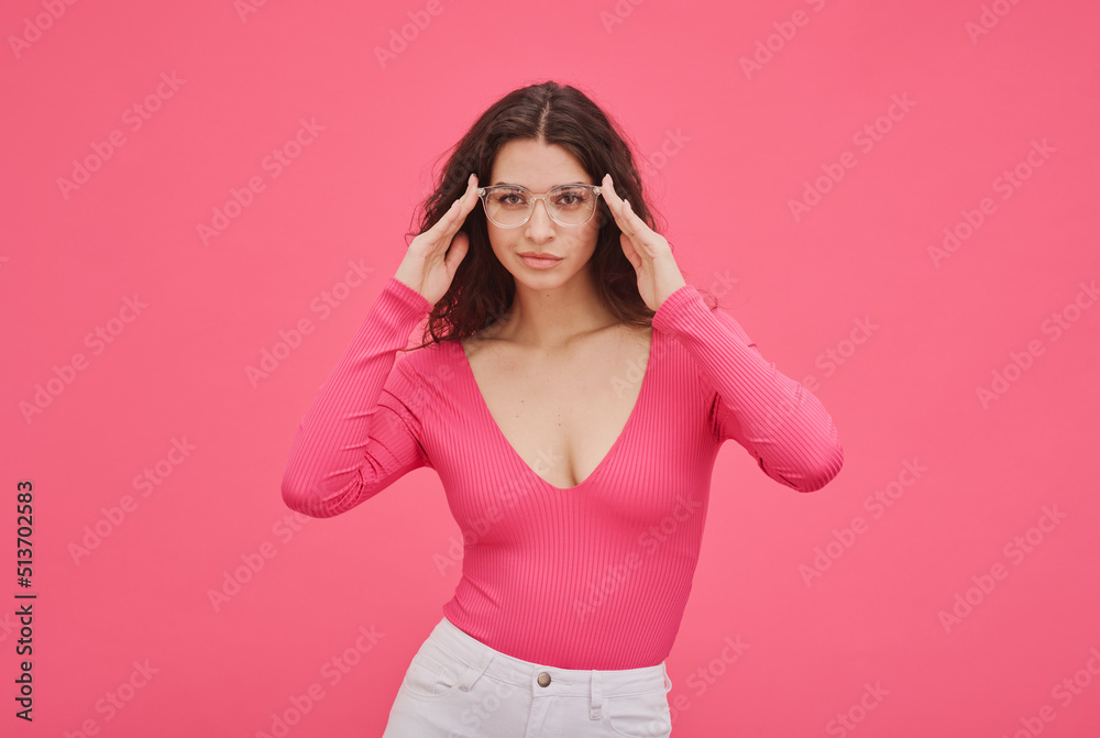 Portrait of cheeky girl in pink in stylish eyeglasses standing against pink background Portrait of cheeky girl in pink in stylish eyeglasses standing against pink background