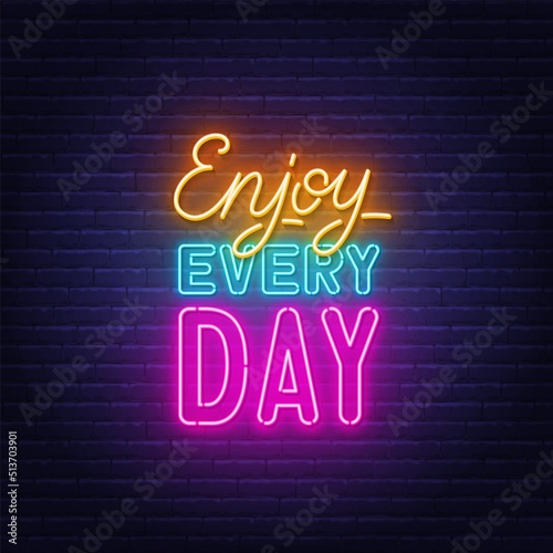 Enjoy Every day neon quote on brick wall background.