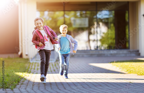 Girl and boy running from school after studying at it.