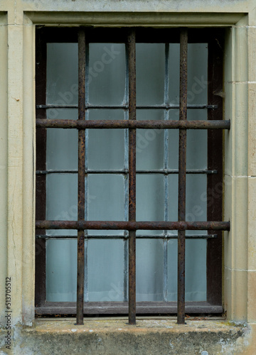 Barred window of a medieval building. Might be a prison or a bank vault.