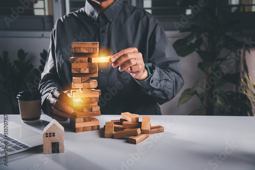 Alternative risk plan. Business hand playing tower wooden blocks game, man pull one wood block from tower he clenched his fist, show great joy in accomplishing it, Business gambling growth concept