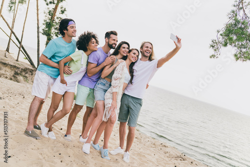 Photo of attractive beautiful best buddies walking hugging recording self video enjoying summer time outdoors ocean seaside