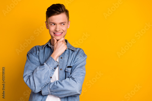 Photo of young excited guy hand tocuh chin look empty space idea wonder isolated over yellow color background