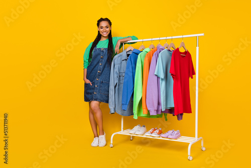 Full size portrait of pretty nice lady standing near wardrobe toothy smile isolated on yellow color background