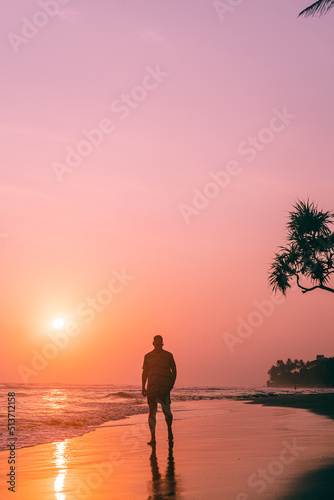 Male model  traveler walking the beach with sunset and ocean background  holiday tropical landscape.