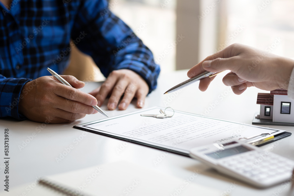 Fototapeta premium Real estate agents negotiate the terms of the home purchase contract and sign the contract legally. Home insurance concept.