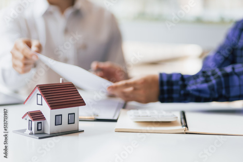 Real estate agents negotiate the terms of the home purchase contract and sign the contract legally. Home insurance concept.