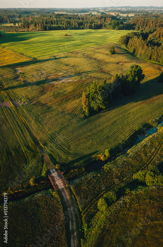 Aerial view on small countryside river in sunset time with old bridge, latvian country side view