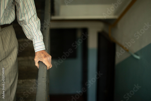 Old man leans on handrail. Old man goes down stairs. Entrance details.