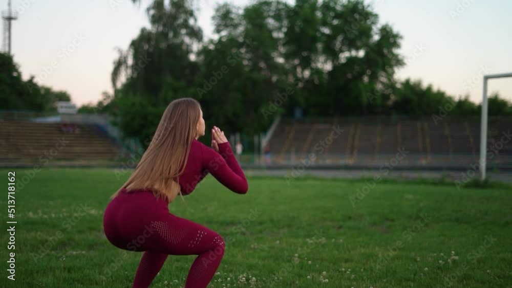 sportswoman goes in for sports on green grass, outdoor sports, summer, healthy lifestyle. jumping squat sportswoman goes in for sports on green grass, outdoor sports, summer, healthy lifestyle. jumping squat