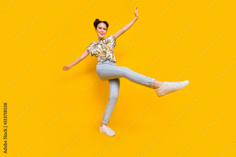 Photo of adorable sweet lady dressed print t-shirt smiling walking dancing isolated yellow color background
