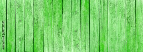 Old wooden boards with weathered bright green grass color paint wide texture. Shabby wood plank rustic vintage background