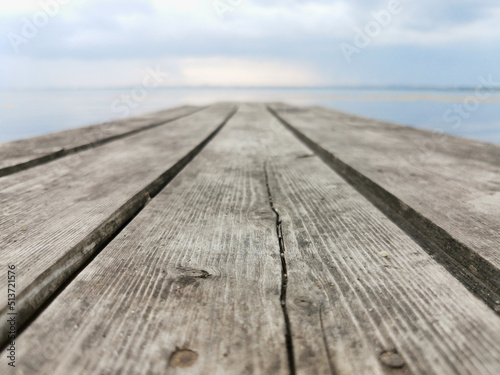 an old wooden bridge against the background of water and sky