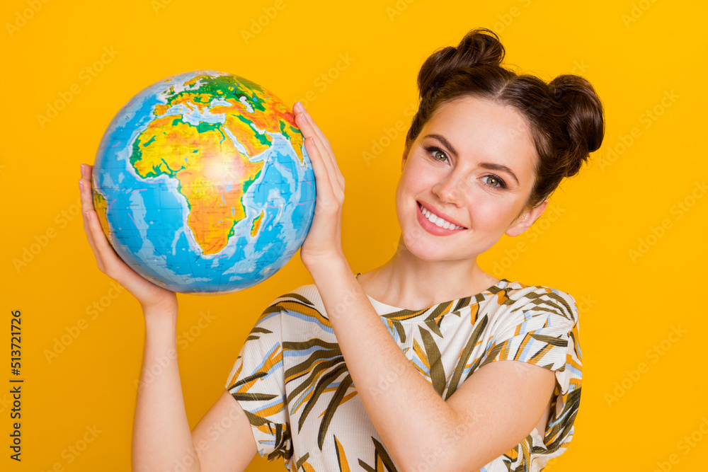 Photo of sweet pretty woman wear print t-shirt holding planet smiling isolated yellow color background Photo of sweet pretty woman wear print t-shirt holding planet smiling isolated yellow color background