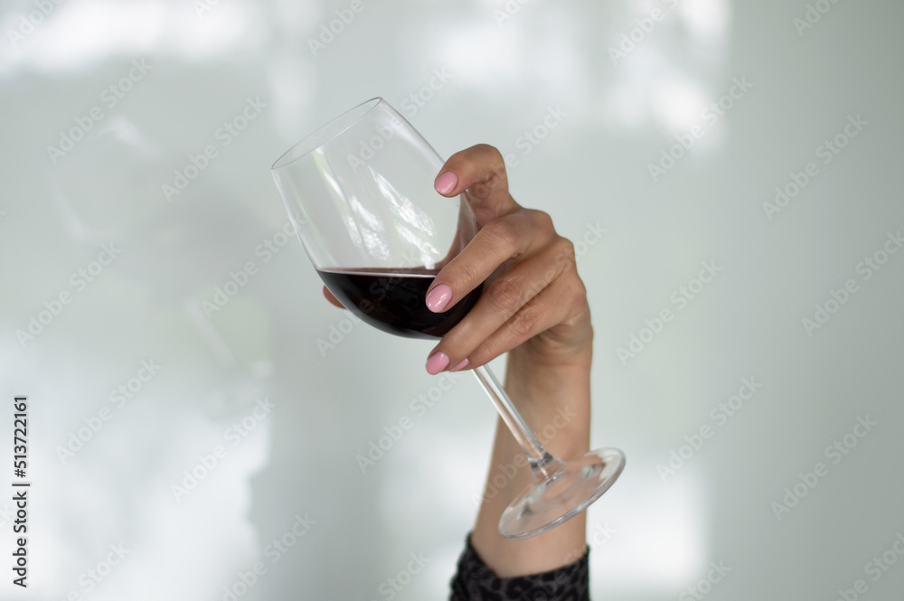 Human hand holding a glass with red wine Human hand holding a glass with red wine