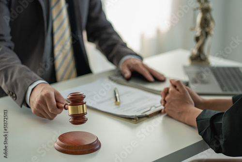 Male attorneys or judges consult teams with clients, business and legal services. The consultant presents the contract signed with the hammer placed in front and concept of justice and lawyer