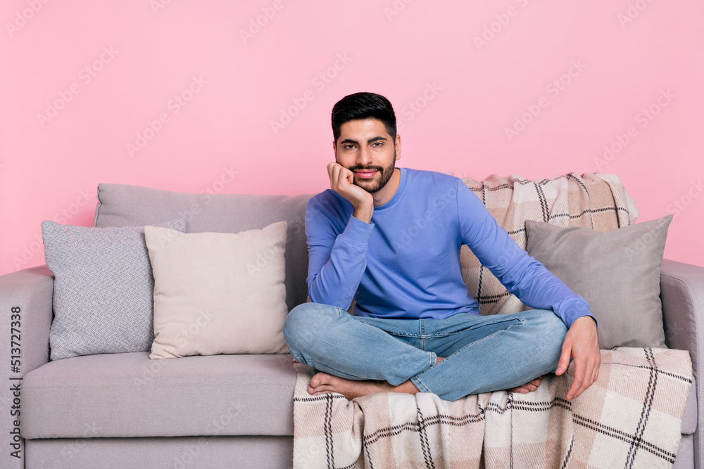 Photo of cute funny arabian man wear long sleeve shirt sitting sofa arm chin empty space isolated pink color background