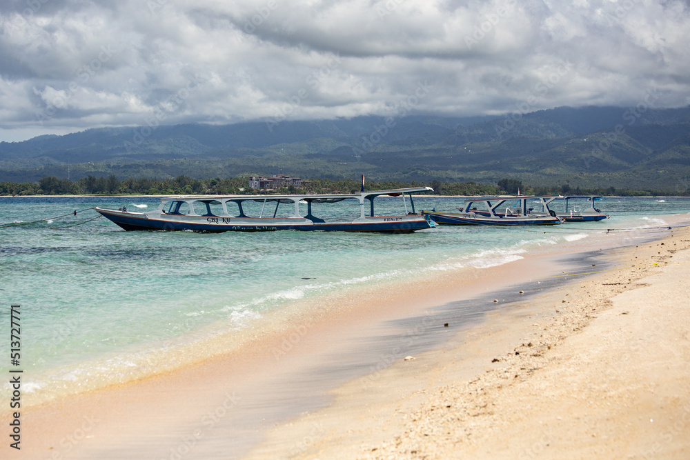 Gili Meno seascape with blue water and clouds, boats on the water, Bali, Indonesia
