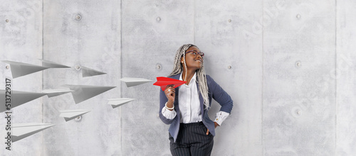 Young beautiful african woman holding hand model paper air plane. Design of travel concept with air plane on empty gray color background photo