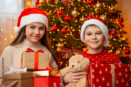 Children with many presents under christmas tree. Christmas morning, receiving presents from Santa concept