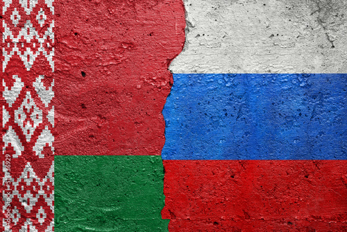 Belarus and Russia - Cracked concrete wall painted with a Belarusian flag on the left and a Russian flag on the right stock photo
