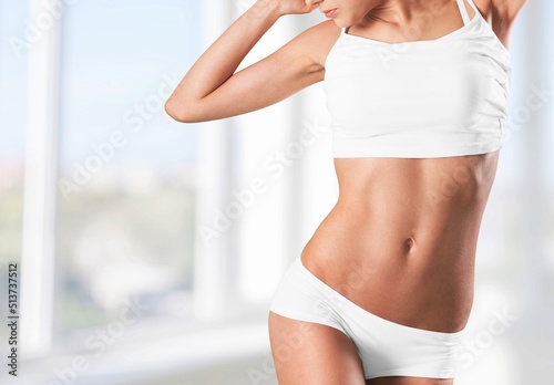 Slim woman wearing sportive underwear and dressing gown at home. Healthy female body.