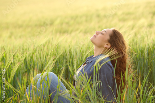 Woman sitting in a wheat field breathing fresh air