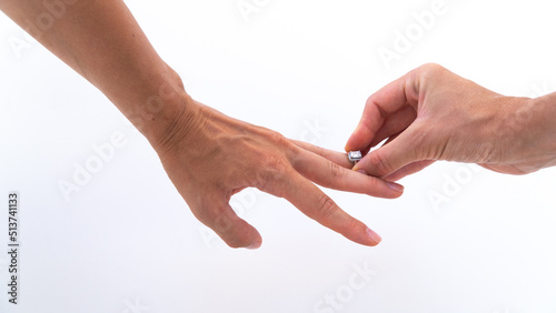 put on a wedding ring on a finger on a white background