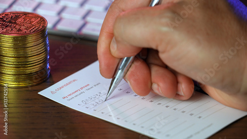 A closeup view of a man writing his secret cryptocurrency wallet recovery 