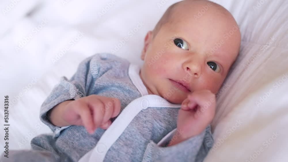 newborn. baby newborn a close-up lies looking at the camera in the hospital maternity hospital. happy family baby dream concept. cute newborn baby lifestyle in gray clothes newborn. baby newborn a close-up lies looking at the camera in the hospital maternity hospital. happy family baby dream concept. cute newborn baby lifestyle in gray clothes