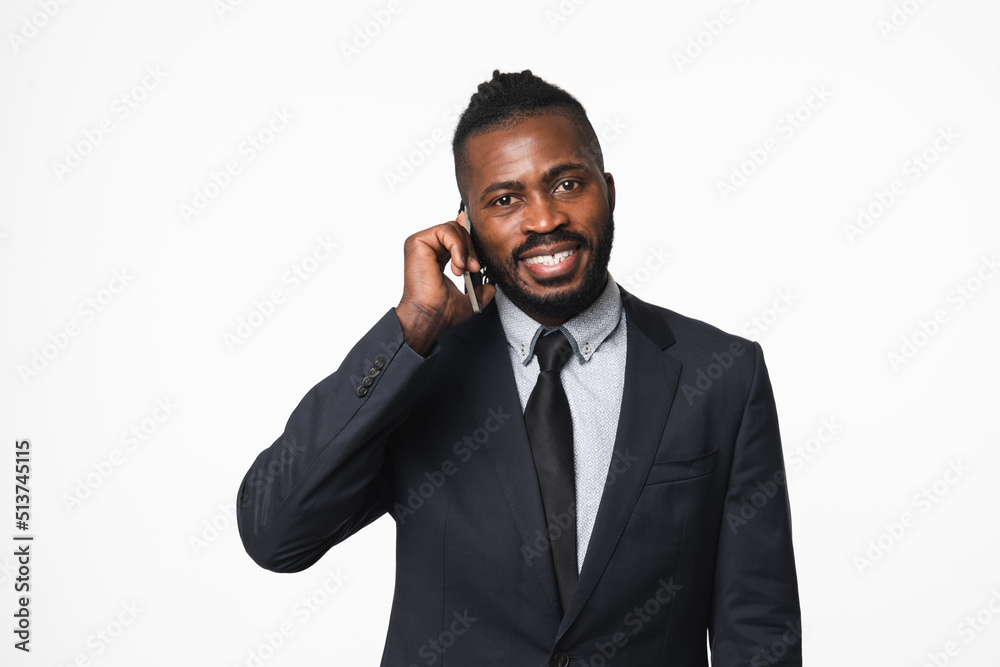 Successful african-american young businessman leader ceo boss bank manager in formal suit talking on cellphone with customers clients online on mobile application isolated in white background Successful african-american young businessman leader ceo boss bank manager in formal suit talking on cellphone with customers clients online on mobile application isolated in white background