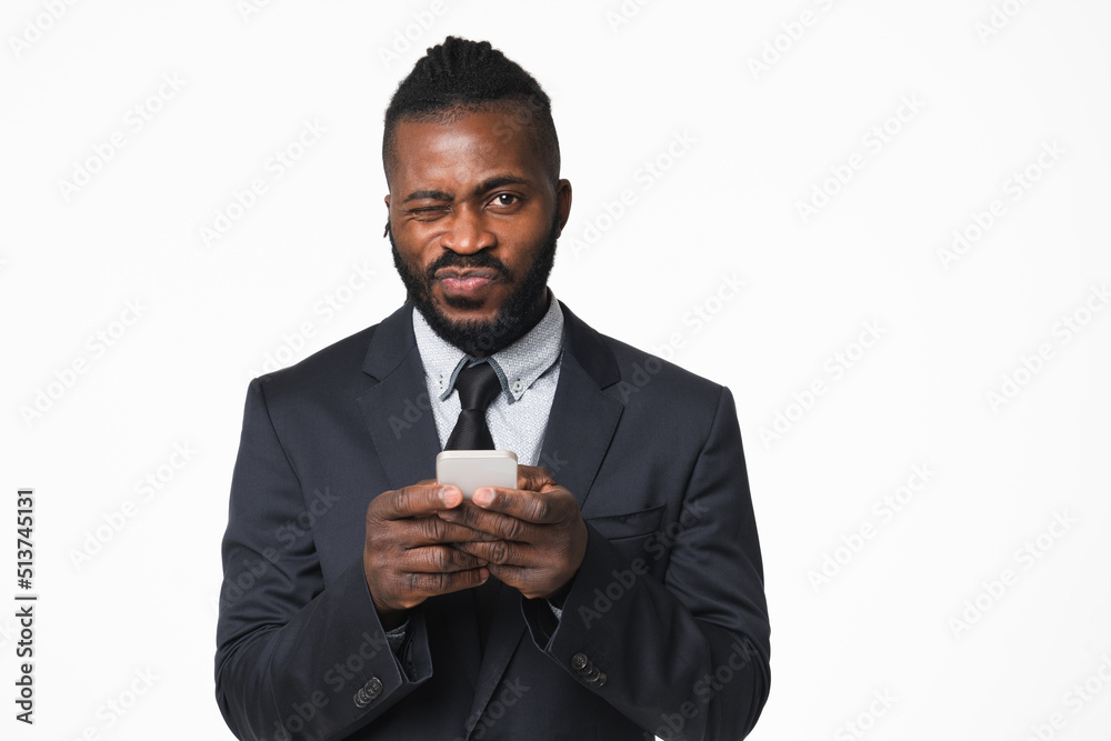 Cheerful african young businessman ceo leader boss in formal suit using cellphone for e-learning e-banking online, reading news, browsing social media isolated in white background Cheerful african young businessman ceo leader boss in formal suit using cellphone for e-learning e-banking online, reading news, browsing social media isolated in white background