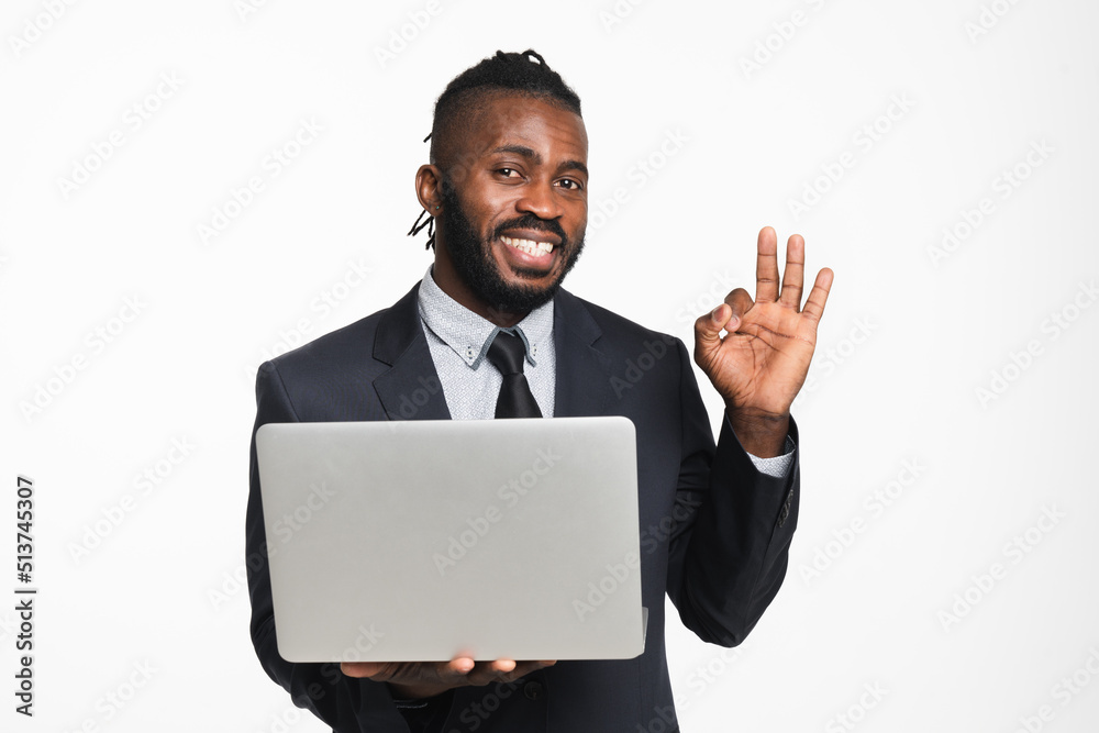 Successful african businessman ceo leader boss bank manager showing okay gesture using laptop for e-banking e-commerce, e-learning, watching webinars isolated in white background Successful african businessman ceo leader boss bank manager showing okay gesture using laptop for e-banking e-commerce, e-learning, watching webinars isolated in white background