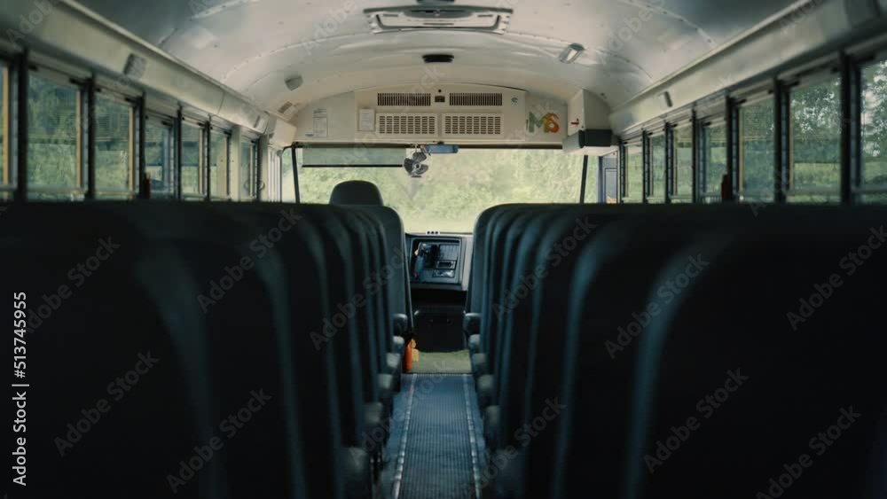 Empty aisle black seats in schoolbus. Bus interior without passengers close up. Empty aisle black seats in schoolbus. Bus interior without passengers close up.