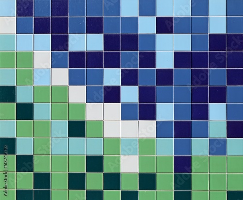 Exterior wall made of small squared tiles. Colors are blue, light blue,white,light green and green. Mosaic effect, background and texture.